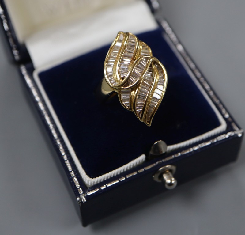 An 18k and trapeze cut diamond cluster set modernist dress ring, size L, gross 8.4 grams.